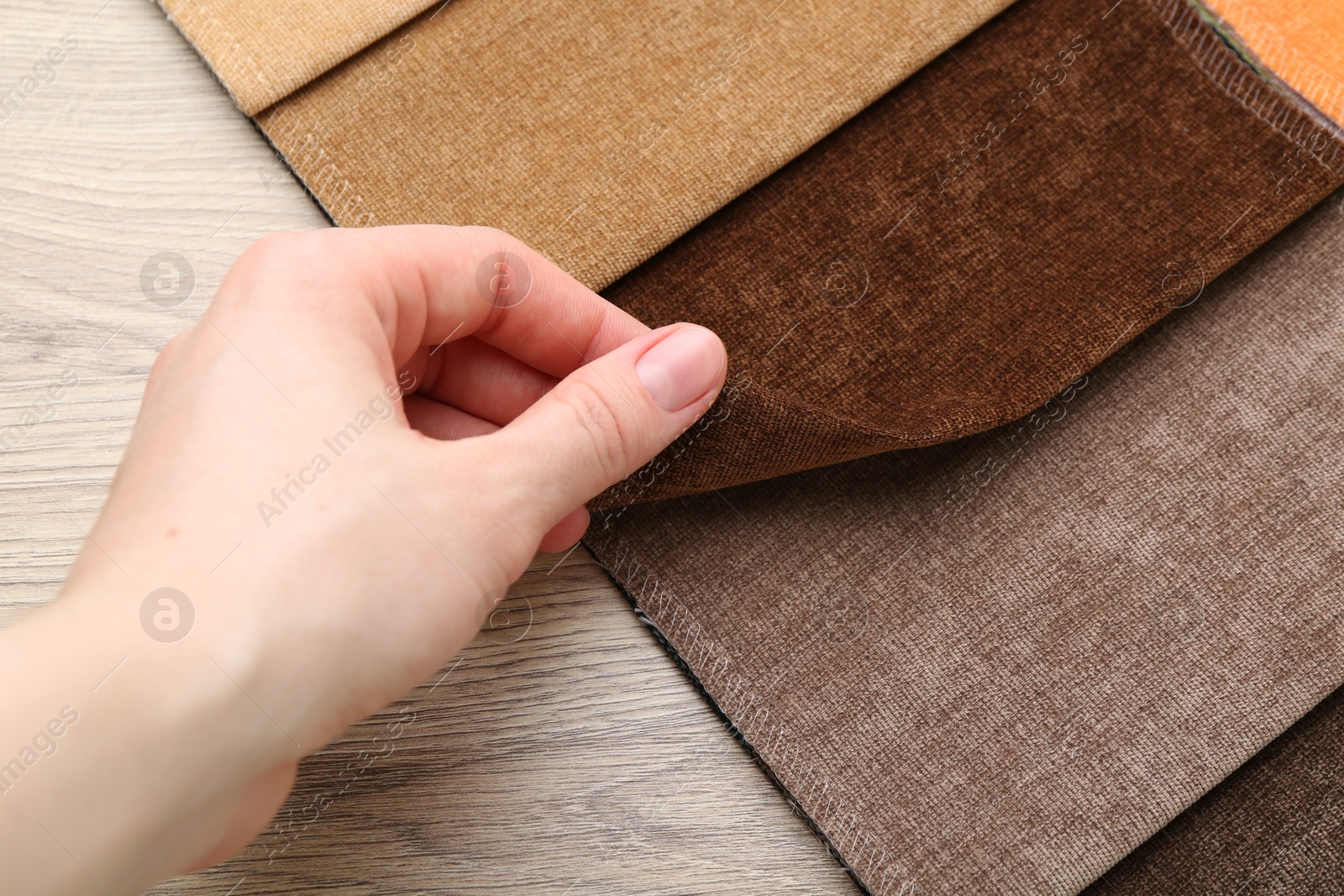 Woman with samples of different fabrics at wooden table, closeup Photo of Woman with samples of different fabrics at wooden table, closeup