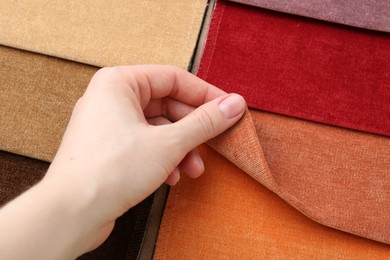 Photo of Woman with samples of different fabrics, closeup