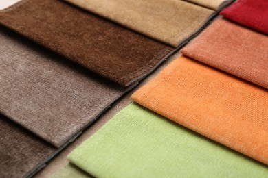 Photo of Samples of different fabrics as background, closeup