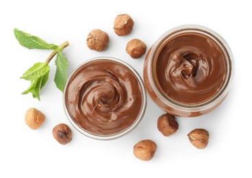 Photo of Tasty chocolate spread, hazelnuts and mint isolated on white, top view