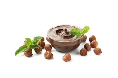 Photo of Tasty chocolate spread with mint in bowl and hazelnuts isolated on white
