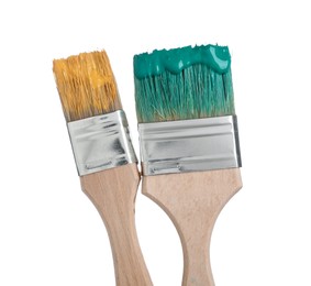 Photo of Brushes with green and orange paints isolated on white