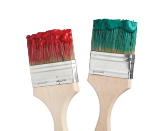 Photo of Brushes with green and red paints isolated on white