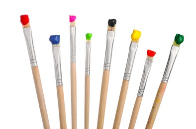 Photo of Brushes with different paints isolated on white