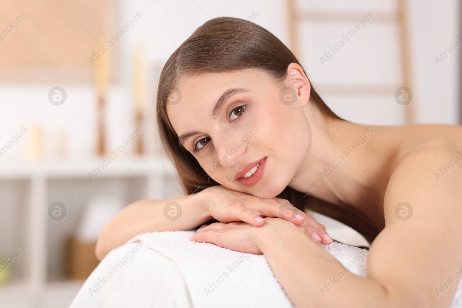 Portrait of smiling woman on massage couch in spa salon Photo of Portrait of smiling woman on massage couch in spa salon