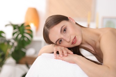 Photo of Portrait of smiling woman on massage couch in spa salon