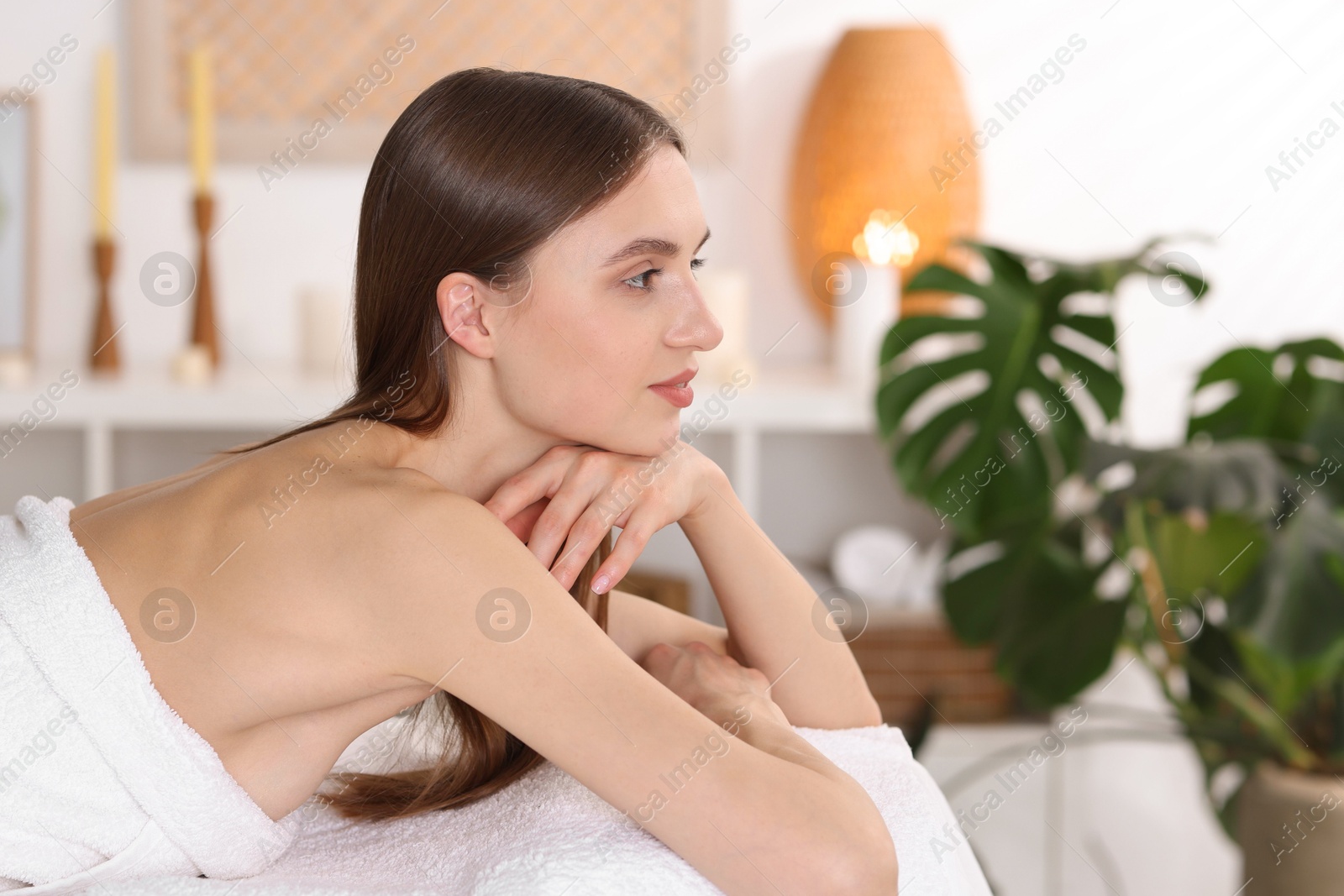 Beautiful woman relaxing on massage couch in spa salon Photo of Beautiful woman relaxing on massage couch in spa salon