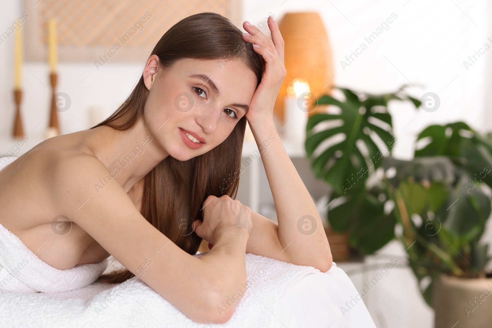 Portrait of beautiful woman on massage couch in spa salon Photo of Portrait of beautiful woman on massage couch in spa salon