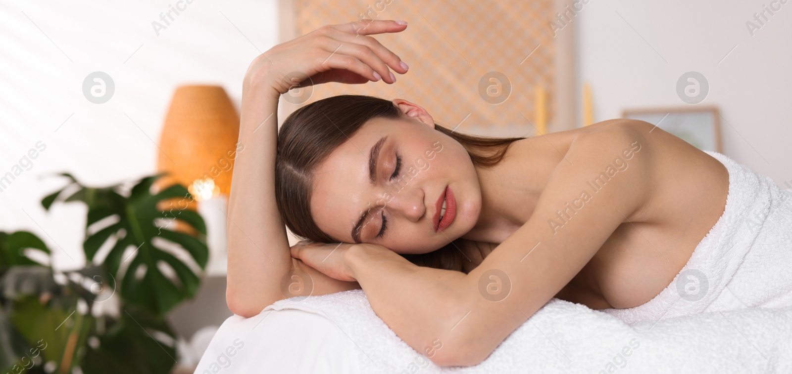Beautiful woman relaxing on massage couch in spa salon Photo of Beautiful woman relaxing on massage couch in spa salon
