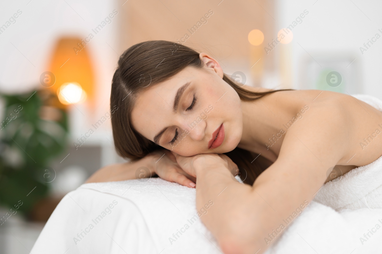 Beautiful woman relaxing on massage couch in spa salon Photo of Beautiful woman relaxing on massage couch in spa salon