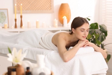 Photo of Beautiful woman relaxing on massage couch in spa salon, selective focus