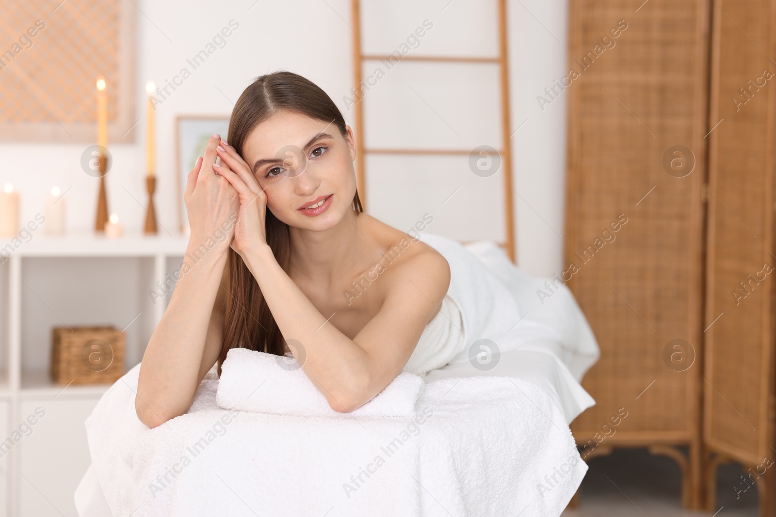 Portrait of beautiful woman on massage couch in spa salon Photo of Portrait of beautiful woman on massage couch in spa salon
