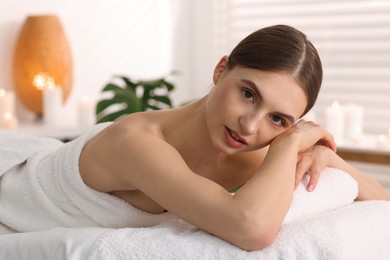 Photo of Portrait of beautiful woman on massage couch in spa salon