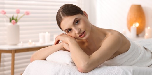 Photo of Portrait of beautiful woman on massage couch in spa salon