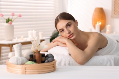Photo of Beautiful woman relaxing on massage couch in spa salon, selective focus