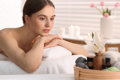 Photo of Beautiful woman relaxing on massage couch in spa salon