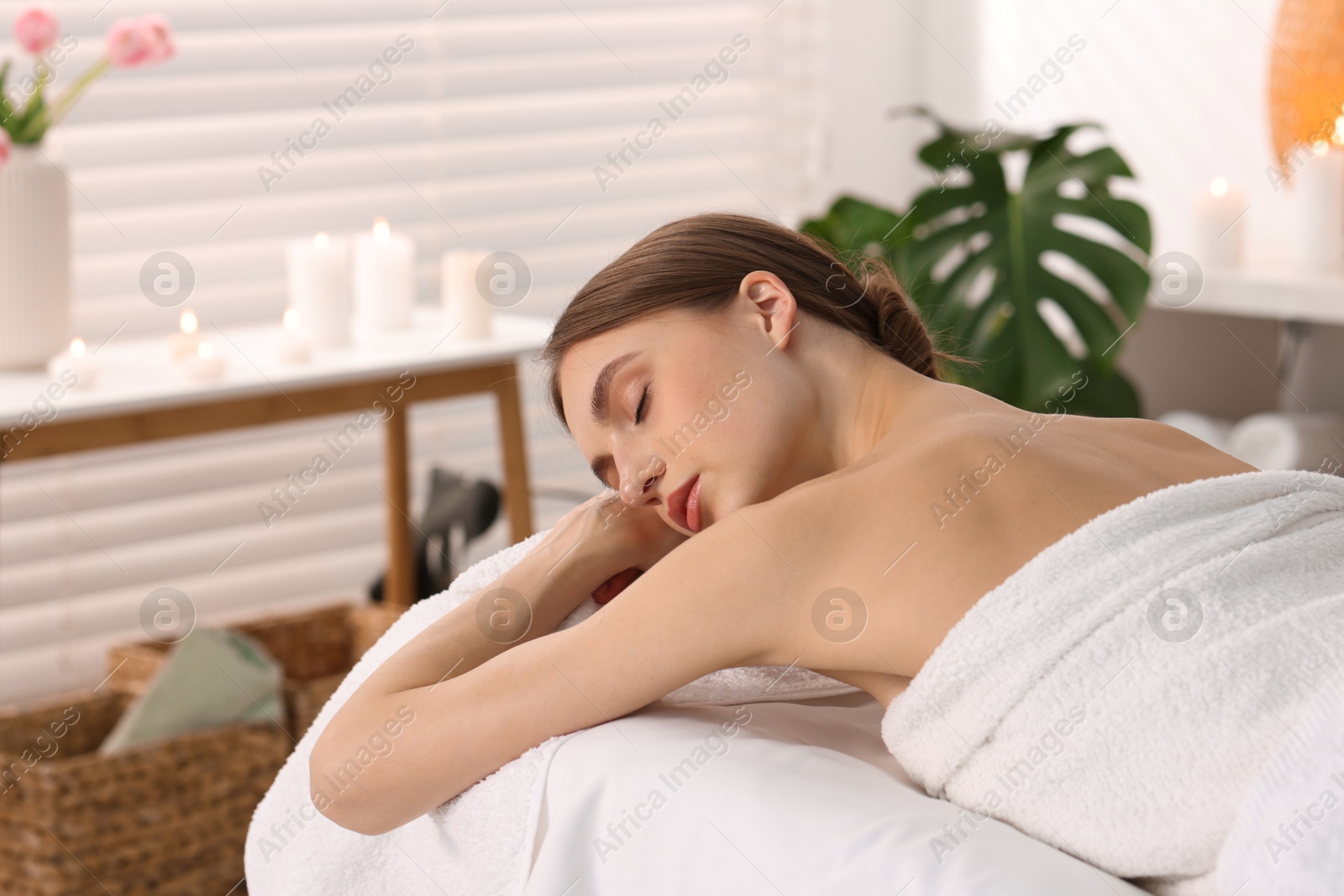Beautiful woman relaxing on massage couch in spa salon Photo of Beautiful woman relaxing on massage couch in spa salon