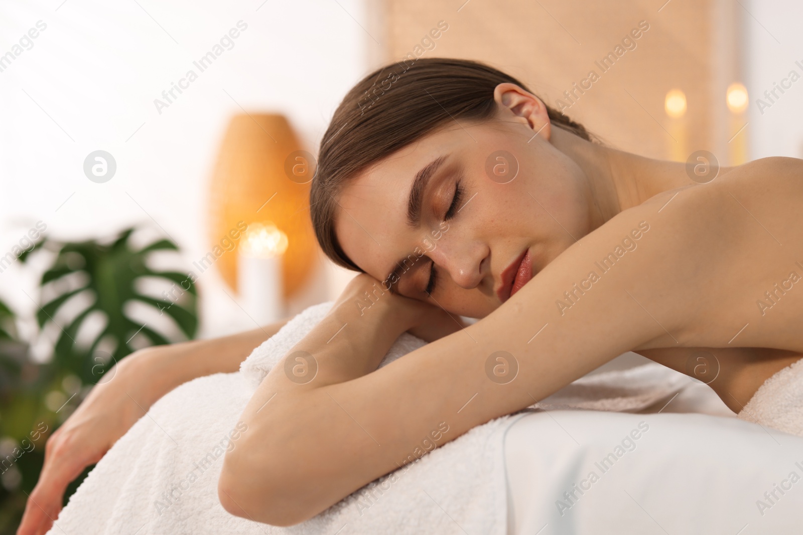 Beautiful woman relaxing on massage couch in spa salon Photo of Beautiful woman relaxing on massage couch in spa salon