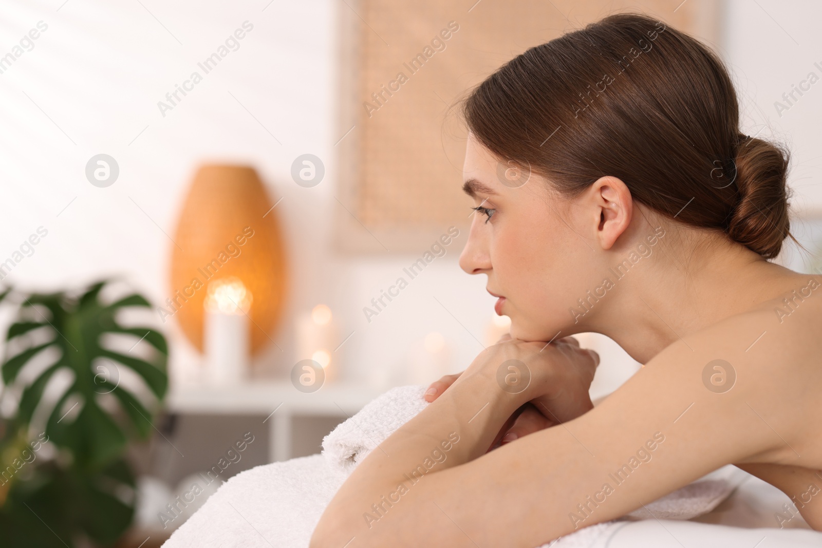 Beautiful woman relaxing on massage couch in spa salon. Space for text Photo of Beautiful woman relaxing on massage couch in spa salon. Space for text