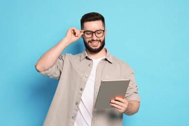 Photo of Man using tablet on light blue background