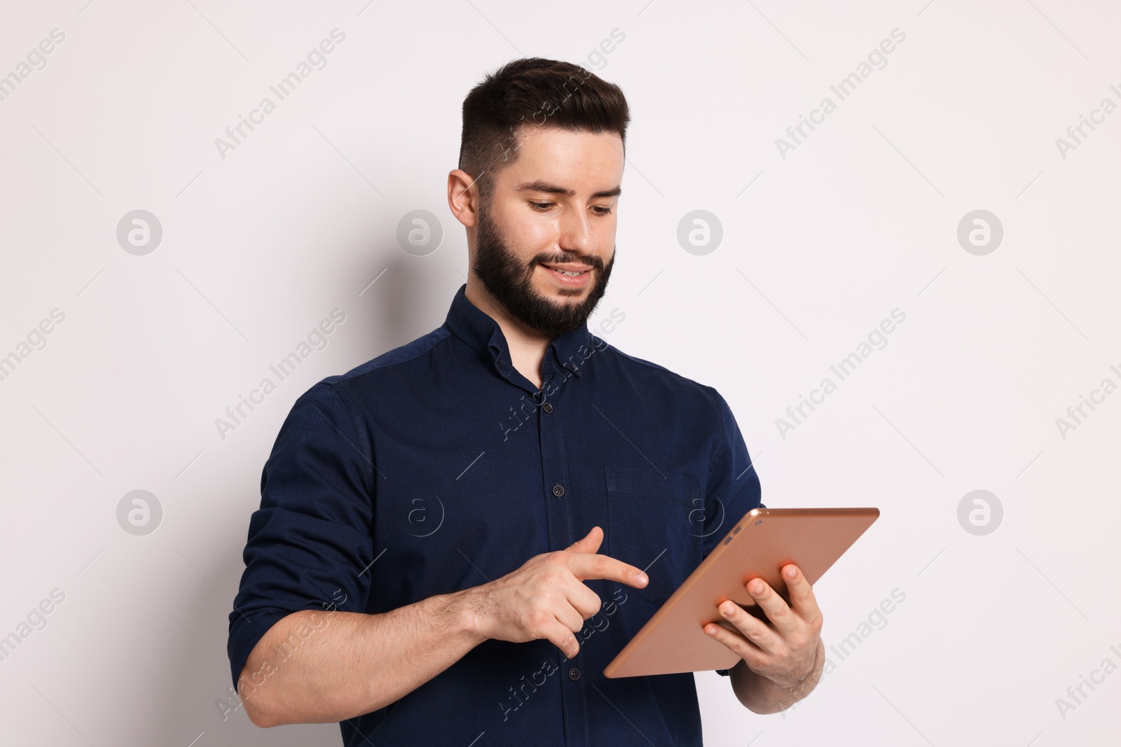 Handsome man using tablet on white background Photo of Handsome man using tablet on white background