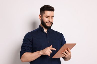 Photo of Handsome man using tablet on white background