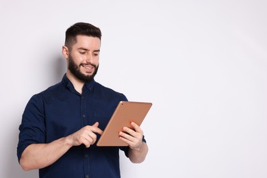 Photo of Handsome man using tablet on white background, space for text