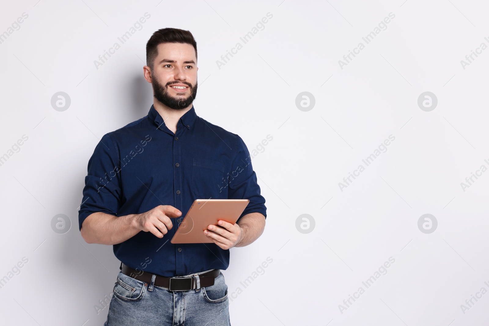 Handsome man using tablet on white background, space for text Photo of Handsome man using tablet on white background, space for text