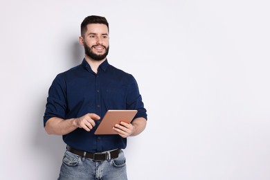 Photo of Handsome man using tablet on white background, space for text