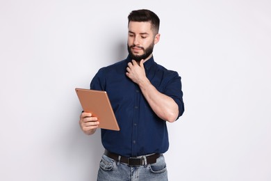 Photo of Handsome man using tablet on white background