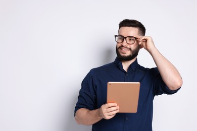 Photo of Handsome man using tablet on white background, space for text