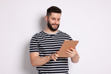 Photo of Handsome man using tablet on white background