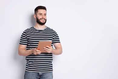Photo of Handsome man using tablet on white background, space for text