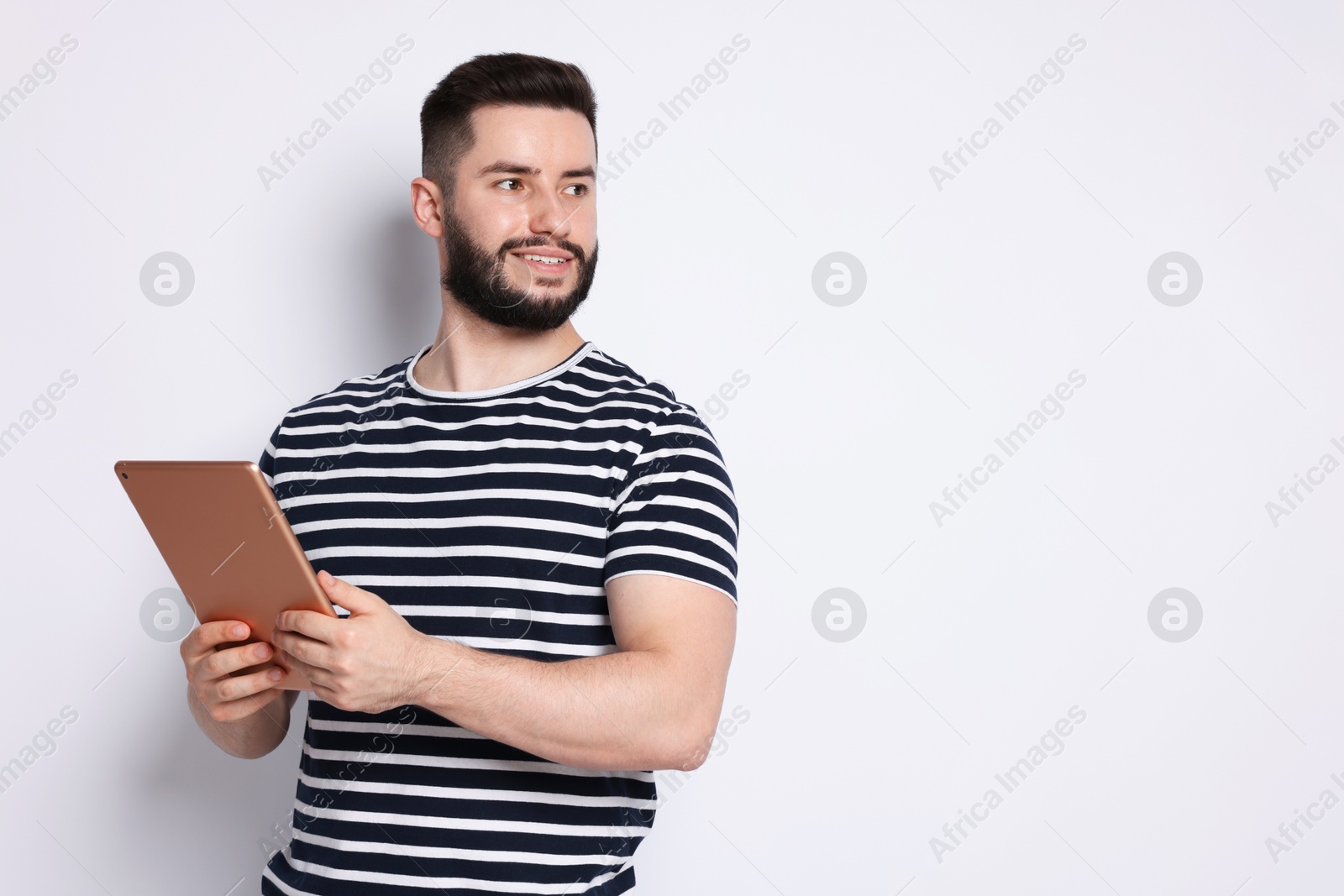 Handsome man using tablet on white background, space for text Photo of Handsome man using tablet on white background, space for text