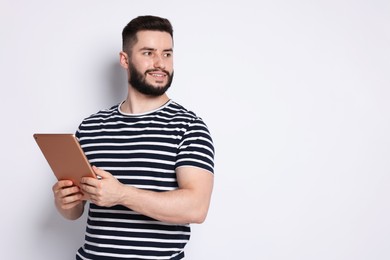 Photo of Handsome man using tablet on white background, space for text