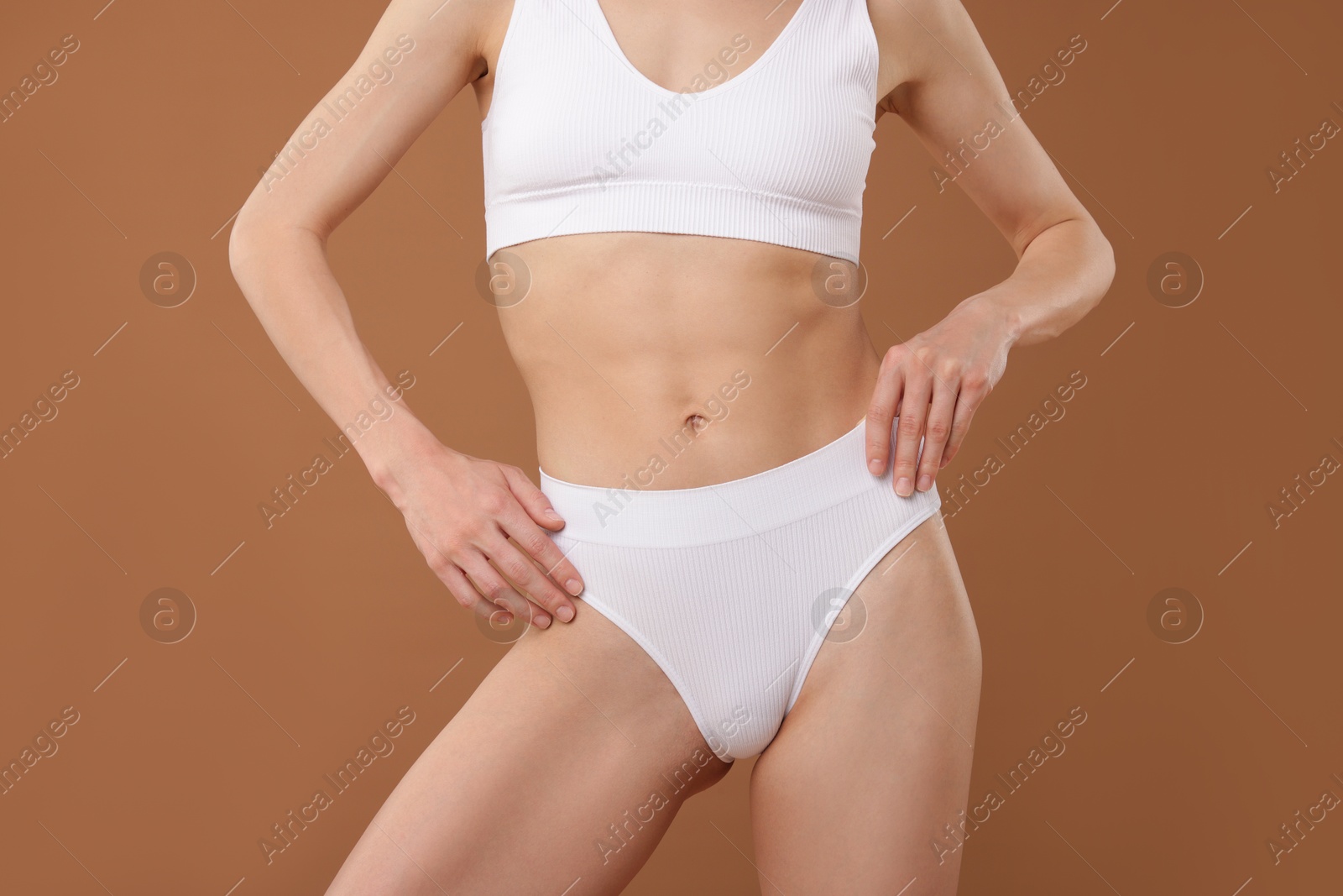 Woman with perfect slim body on beige background, closeup Photo of Woman with perfect slim body on beige background, closeup