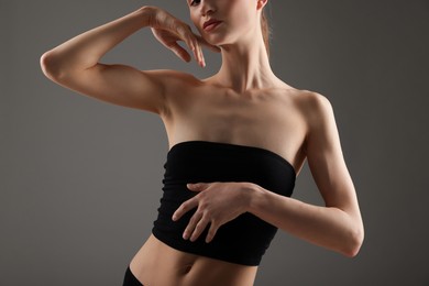 Photo of Woman with perfect slim body on grey background, closeup