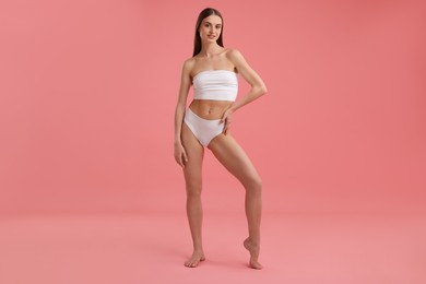 Photo of Beautiful woman with perfect slim body on pink background