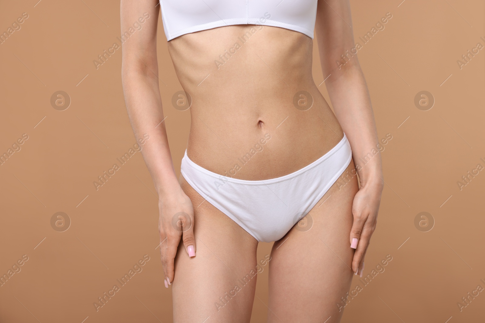 Woman with perfect slim body on beige background, closeup Photo of Woman with perfect slim body on beige background, closeup