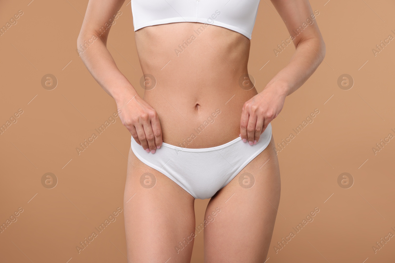 Woman with perfect slim body on beige background, closeup Photo of Woman with perfect slim body on beige background, closeup