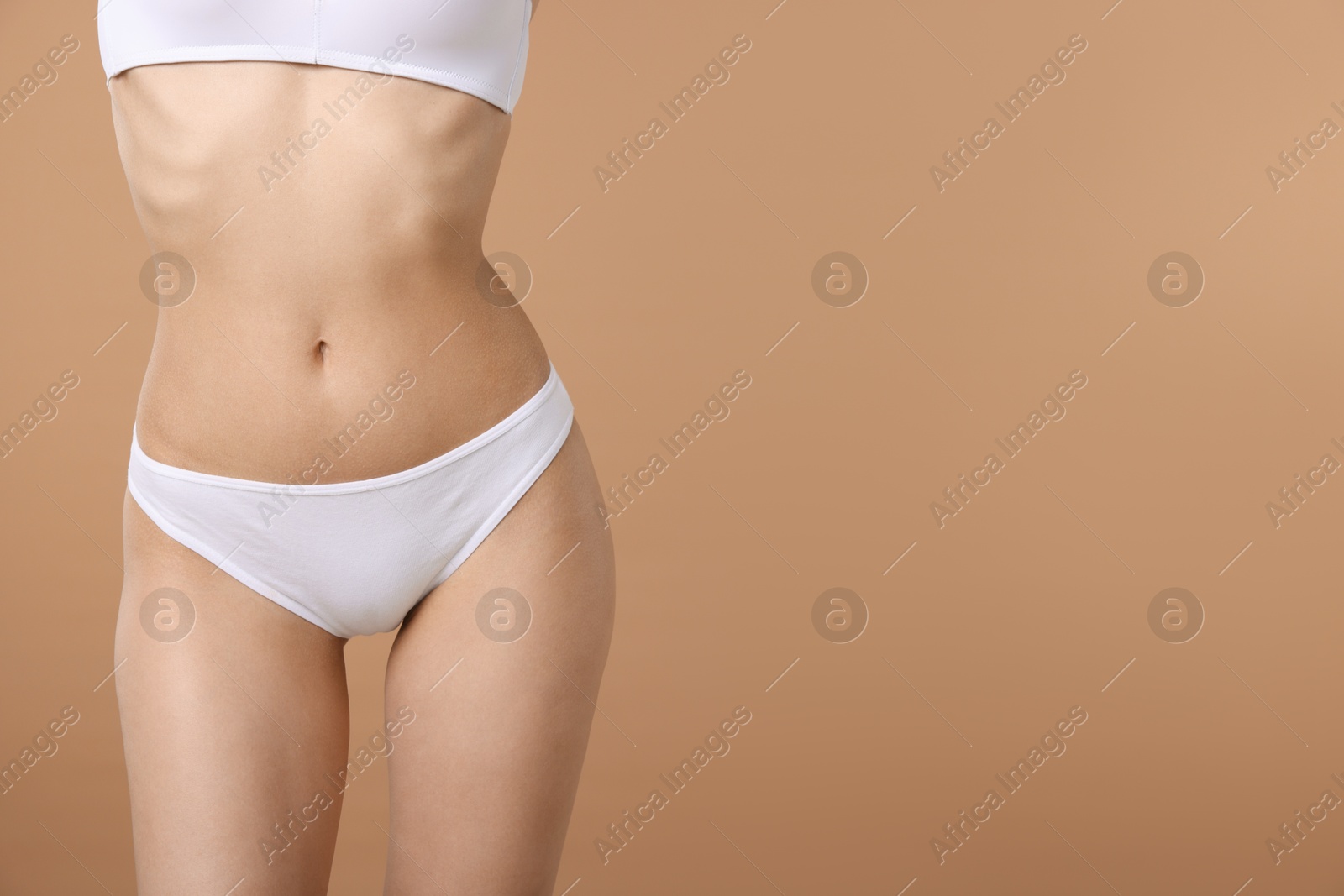 Woman with perfect slim body on beige background, closeup. Space for text Photo of Woman with perfect slim body on beige background, closeup. Space for text