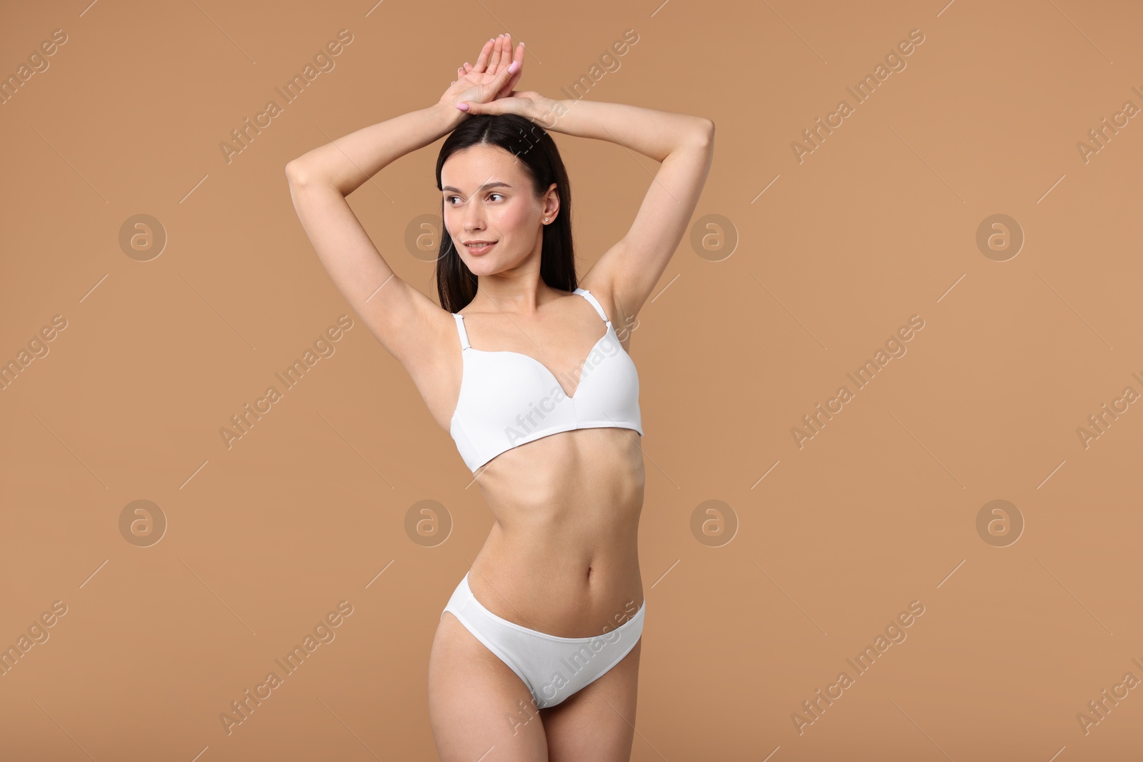 Woman with perfect slim body on beige background Photo of Woman with perfect slim body on beige background