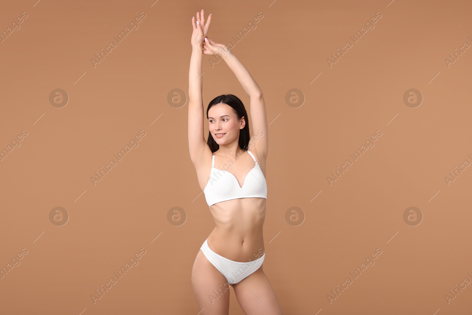 Woman with perfect slim body on beige background Photo of Woman with perfect slim body on beige background