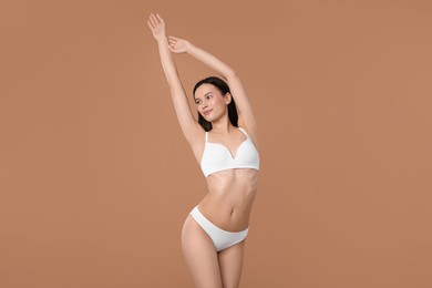 Photo of Woman with perfect slim body on beige background