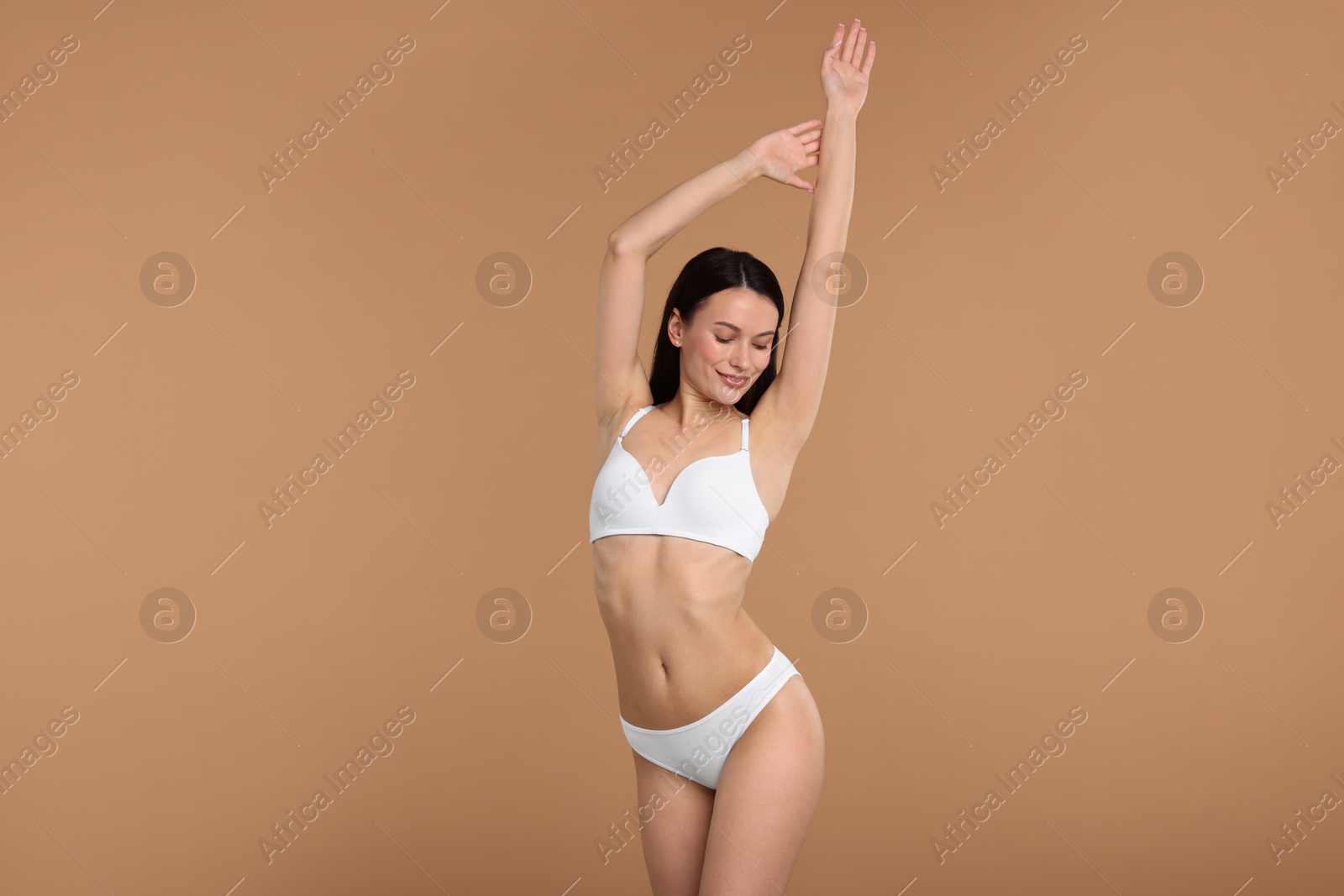 Woman with perfect slim body on beige background Photo of Woman with perfect slim body on beige background