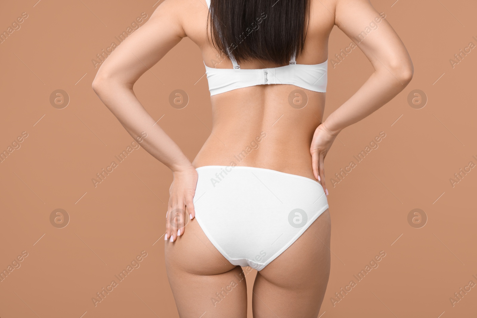 Woman with perfect slim body on beige background, closeup Photo of Woman with perfect slim body on beige background, closeup