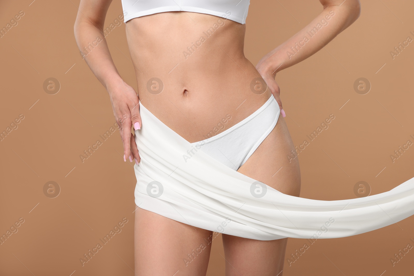 Woman with beautiful fabric on beige background, closeup Photo of Woman with beautiful fabric on beige background, closeup