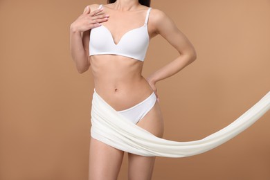 Photo of Woman with beautiful fabric on beige background, closeup