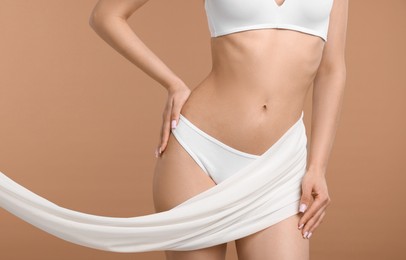 Photo of Woman with beautiful fabric on beige background, closeup