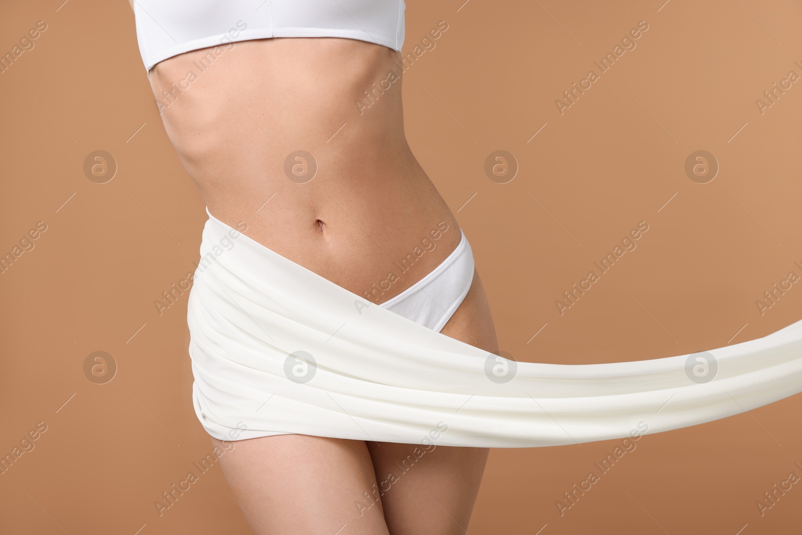 Woman with beautiful fabric on beige background, closeup Photo of Woman with beautiful fabric on beige background, closeup